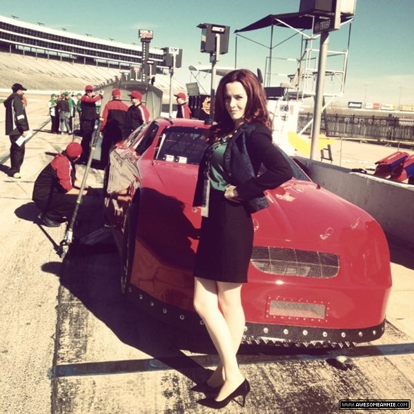 Annie Wersching poses next to racecar on Dallas set