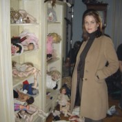 Annie Wersching poses next to dolls on Supernatural set