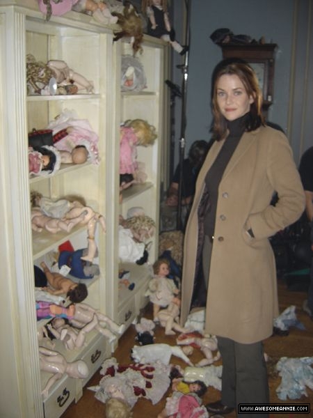 Annie Wersching poses next to dolls on Supernatural set